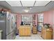 Kitchen showcasing stainless steel refrigerator, island on wheels and tiled floors at 8914 Schrader Blvd, Port Richey, FL 34668