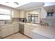 Bright kitchen with white cabinets, stainless steel appliances, and view to the outdoor patio at 9003 Lido Ln, Port Richey, FL 34668