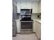 Kitchen featuring stainless steel oven, microwave, white cabinets, and tiled backsplash at 9003 Lido Ln, Port Richey, FL 34668