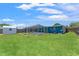A spacious backyard features a screened pool, lush lawn, utility shed, and privacy fence at 9016 Unicorn Ave, Port Richey, FL 34668