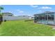 Fenced backyard features a well-maintained lawn, utility shed, and screened pool at 9016 Unicorn Ave, Port Richey, FL 34668