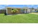 Well-maintained home with green lawn, featuring mature landscaping with small palms accenting the facade at 9016 Unicorn Ave, Port Richey, FL 34668