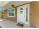 Close-up of the front entry highlighting a well-lit, inviting door with decorative wreath and house number at 9016 Unicorn Ave, Port Richey, FL 34668