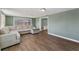 Comfortable living room featuring wood-look floors, a sectional sofa, and access to other rooms at 9016 Unicorn Ave, Port Richey, FL 34668