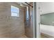 Modern shower with rainfall head, body spray, and mosaic tile accent in updated bathroom at 9016 Unicorn Ave, Port Richey, FL 34668