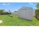 A storage shed sits on a well-manicured lawn in the backyard at 9016 Unicorn Ave, Port Richey, FL 34668