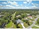 Aerial view of home featuring a screened-in pool, long driveway, and lush landscaping at 9431 Amidon St, Spring Hill, FL 34608