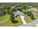 Aerial view of a beautiful home featuring a screened-in pool and a long driveway surrounded by lush landscaping at 9431 Amidon St, Spring Hill, FL 34608