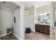 View of bathroom with double vanity, granite counters, a walk-in shower, and rustic wood-look floors at 9431 Amidon St, Spring Hill, FL 34608