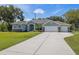 Charming single-story home features a manicured lawn, mature trees, and a three-car garage at 9431 Amidon St, Spring Hill, FL 34608
