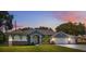 Charming single-story home with lush lawn, mature trees, and a convenient three-car garage at 9431 Amidon St, Spring Hill, FL 34608