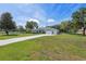 Lovely single-story home on expansive green lawn with mature trees on a partly cloudy day at 9431 Amidon St, Spring Hill, FL 34608