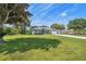 Lovely single-story home on expansive green lawn with mature trees on a partly cloudy day at 9431 Amidon St, Spring Hill, FL 34608