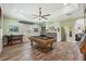 Well-lit game room with hardwood floors, ceiling fan, pool table, and bar area at 9431 Amidon St, Spring Hill, FL 34608