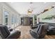Bright living room with hardwood floors, ceiling fan, entertainment center, and leather furniture at 9431 Amidon St, Spring Hill, FL 34608
