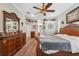 Spacious main bedroom featuring hardwood floors, ceiling fan, and elegant furniture at 9431 Amidon St, Spring Hill, FL 34608