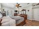 Primary bedroom with hardwood floors, elegant furniture, a ceiling fan, and French door access at 9431 Amidon St, Spring Hill, FL 34608