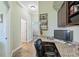 Office with granite countertop desk area, wall shelving, and wood-look floors at 9431 Amidon St, Spring Hill, FL 34608