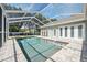 An in-ground pool is encased in a screened-in area, complete with grab rails, a hot tub, and space for sunbathing at 9431 Amidon St, Spring Hill, FL 34608