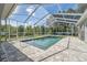 Relaxing screened-in pool area with a jacuzzi and brick-paved deck perfect for outdoor entertaining at 9431 Amidon St, Spring Hill, FL 34608