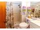 Compact bathroom featuring a shower with floral curtain, and a mirrored medicine cabinet at 9630 Eldridge Rd, Spring Hill, FL 34608