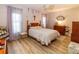 Bright bedroom with two windows, wood-look floors, and a classic dresser at 9630 Eldridge Rd, Spring Hill, FL 34608