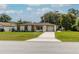 Charming single-story home with stone accents, a well-manicured lawn, and a concrete driveway leading to an attached garage at 9630 Eldridge Rd, Spring Hill, FL 34608
