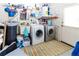 Functional laundry room with washer, dryer, utility sink, and storage shelves at 9630 Eldridge Rd, Spring Hill, FL 34608