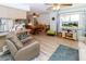Open-concept living space featuring wood-look floors, a cozy recliner, and access to the kitchen at 9630 Eldridge Rd, Spring Hill, FL 34608