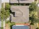 Top-down aerial view of home showcasing the roof, surrounding trees, yard and proximity to a lake at 1010 Teal Pointe, Tarpon Springs, FL 34689