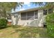 Well-maintained backyard featuring a screened lanai with stairs, and manicured lawn at 1010 Teal Pointe, Tarpon Springs, FL 34689