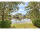 Scenic backyard view overlooking a serene pond, enhanced by lush greenery and mature trees at 1010 Teal Pointe, Tarpon Springs, FL 34689
