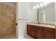 Updated bath features granite countertops, dark wood cabinetry and stone tiled shower at 1010 Teal Pointe, Tarpon Springs, FL 34689