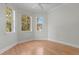 Bright bedroom with wood flooring and large windows providing plenty of natural light and views of the trees at 1010 Teal Pointe, Tarpon Springs, FL 34689