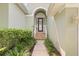 Inviting front entrance with tiled steps, well-maintained landscaping and glass accented front door at 1010 Teal Pointe, Tarpon Springs, FL 34689