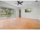 An airy living room with hardwood floors, a ceiling fan, and sliding doors to a screened lanai at 1010 Teal Pointe, Tarpon Springs, FL 34689
