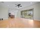 Spacious living room featuring hardwood floors, recessed lighting, fan and screened porch access at 1010 Teal Pointe, Tarpon Springs, FL 34689