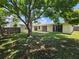 A serene backyard featuring a mature tree, swing, and expansive lawn, perfect for outdoor enjoyment at 10135 Glen Moor Ln, Port Richey, FL 34668