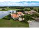 Waterfront home with terracotta roof nestled amid lush greenery, offering a private retreat with scenic views at 10342 Altrara Way, Trinity, FL 34655