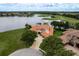 Breathtaking terracotta roof home overlooking a serene lake and a picturesque golf course, set against a lush landscape at 10342 Altrara Way, Trinity, FL 34655