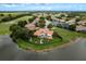 An aerial view of the beautiful home showcasing the manicured lawn, lake views, and putting green at 10342 Altrara Way, Trinity, FL 34655