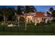 Beautiful backyard with a pool, covered outdoor seating area, putting green, and lush tropical landscaping at 10342 Altrara Way, Trinity, FL 34655