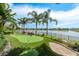 A view of a putting green in the backyard with lake views, and landscaping at 10342 Altrara Way, Trinity, FL 34655