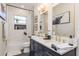 Well-lit bathroom featuring a modern vanity, hexagon tile, tub, and a decorative niche with natural light at 10342 Altrara Way, Trinity, FL 34655
