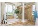Luxurious bathroom featuring a modern soaking tub, stand-up shower and a large window with natural light at 10342 Altrara Way, Trinity, FL 34655
