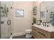Bright bathroom featuring a modern vanity, glass shower and natural lighting at 10342 Altrara Way, Trinity, FL 34655