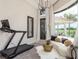 Bright bonus room featuring a treadmill, modern decor, and views of the golf course outside at 10342 Altrara Way, Trinity, FL 34655