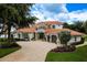 Charming two-story Mediterranean-style home showcases a three-car garage, circular driveway, and professionally landscaped yard at 10342 Altrara Way, Trinity, FL 34655