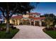 Elegant two-story home boasts a red tile roof, porte cochere, three-car garage, and a brick-paved circular driveway at 10342 Altrara Way, Trinity, FL 34655