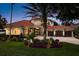 Elegant terracotta roof home features a fountain, lush landscaping, and a grand entrance with a charming three-car garage at 10342 Altrara Way, Trinity, FL 34655